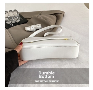 Close-up of the durable wear-resistant bottom structure on the white PU leather underarm bag