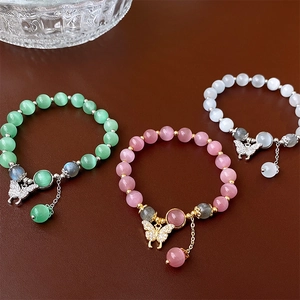 Vue détaillée de bracelets en perles d'œil de chat avec pendentifs papillons élégants