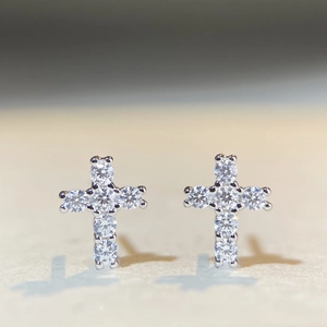 Macro detail of S925 sterling silver cross stud earrings with sparkling moissanite stones