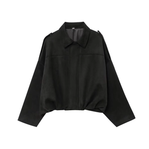Primer plano de chaqueta negra de ante con textura mate, charreteras y hombros caídos