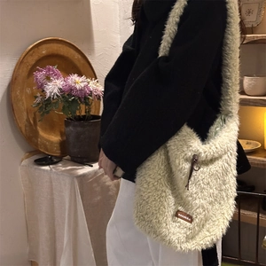 Close-up of soft light green sherpa tote bag with leather accent and sozakka label