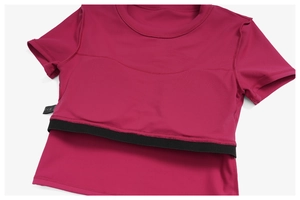 Detail of rose red yoga top showing double-layer support and black elastic hem