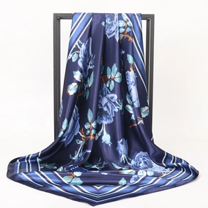 Detail of dark blue floral satin square scarf with elegant draping and silky texture
