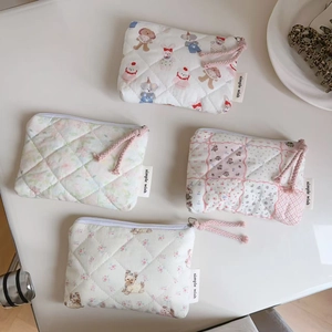 Detailed set of four quilted cartoon floral mini zipper pouches with fabric labels