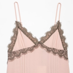 Abito sottoveste rosa con pizzo floreale grigio su sfondo bianco per stile sobrio