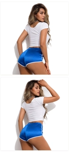Detail showing women's blue satin yoga shorts and white crop top in high-gloss fabric