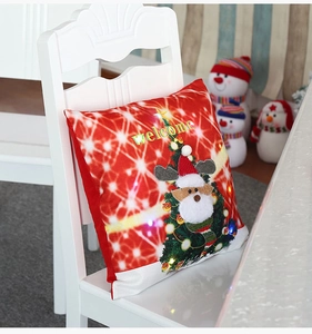 Détail de la housse de coussin de Noël lumineuse LED avec broderie de renne sur chaise