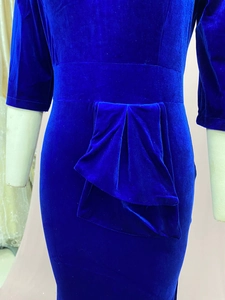 Detailed close-up of blue velvet slim fit dress with a pleated bow waist decoration