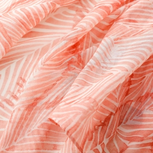 Close-up of orange and white striped bohemian scarf showing soft fabric texture and tassels