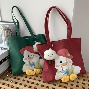 Detail of duck canvas tote bags in green and burgundy with 3D duck feet and plush charm
