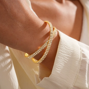 Close-up of gold double-layer crisscross bangle with micro-paved rhinestones on model