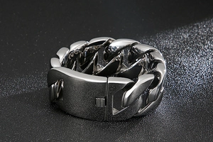 Macro view of polished silver cuban chain bracelet featuring industrial clasp closure