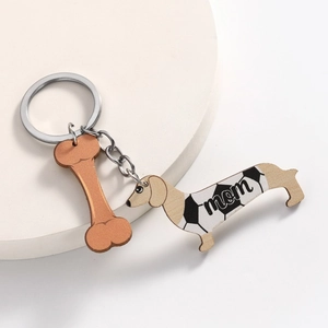 Teckel mama sleutelhanger met voetbalpatroon en botbedel op een luxe display
