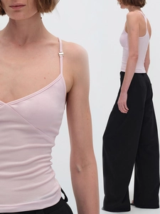 Canotta slim rosa chiaro abbinata a pantaloni neri a vita alta con gamba larga