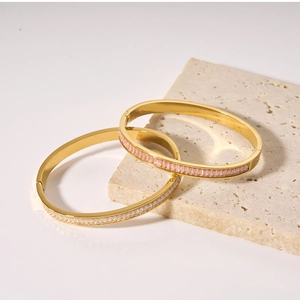 Detail of minimalist gold titanium steel bracelets with pink and white zircon stones