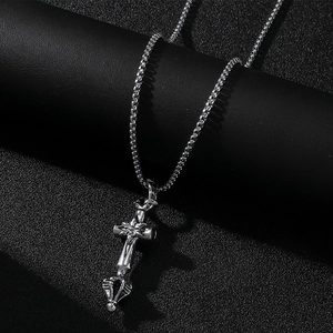 Vue détaillée du pendentif croix et fleur argenté sur une chaîne boîte pour homme