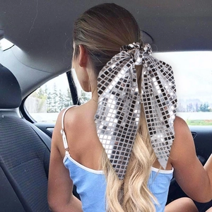 Silver checkered bow hair scrunchie tied on a blonde ponytail for elegant hairstyling