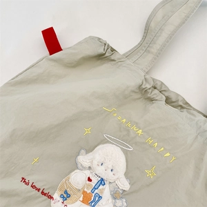 Detail view of the intricate Cinnamoroll embroidery on a light beige canvas tote bag