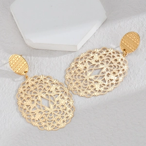 Detailed view of vintage gold hollowed-out floral earrings with intricate geometric patterns