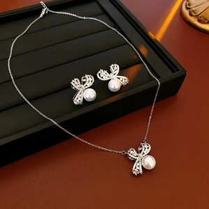 Gros plan d'un ensemble de bijoux nœud en zircon avec perles blanches et chaînes argent