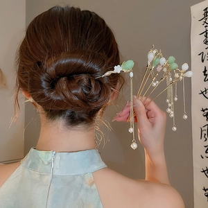 Détail de l'épingle à cheveux avec glands en perles, jade vert et fleurs dorées