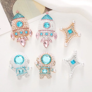 Detail of space-themed alloy pins with pearls and rhinestones for DIY crafts