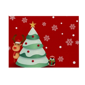 Detailed view of red Christmas table mat featuring reindeer, tree and penguin illustration