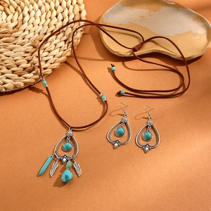 Bohemian jewelry set detail with turquoise stone pendant and vintage silver leaf accents