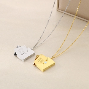 Gros plan de pendentifs enveloppe en or et argent avec gravure Love You sur colliers