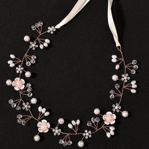 Détail de serre-tête pour fille avec perles blanches, cristaux et fleurs roses