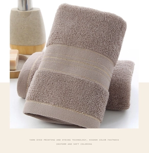 Detailed macro view of brown cotton towel with dense loop pile and golden jacquard stripes