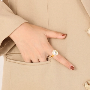 Detail of an 18K gold plated stainless steel ring with a halo of diamonds on a model