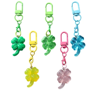 Set mit 5 bunten Kleeblatt-Schlüsselanhängern mit Glitzer-Resin-Anhängern auf weißem Grund