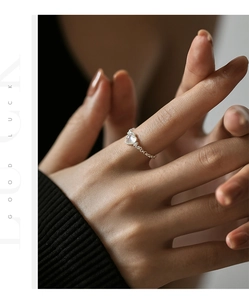 Close-up of S925 silver chain ring featuring heart-shaped moonstone on female hand
