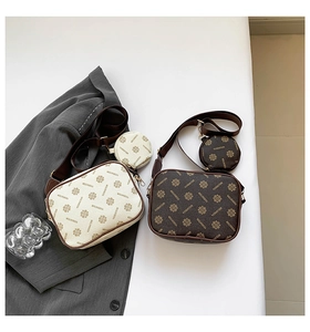 Detail of minimalist cream and brown camera bags with monogram pattern and small pouches