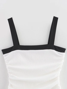 Close-up of black and white smocked fabric texture with wide straps and square neckline