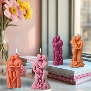 Detailed view of couple-shaped scented candles with rose accents in four warm tones