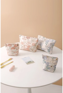 Detailed set of four floral fabric cosmetic bags in soft pink and blue with zip closure