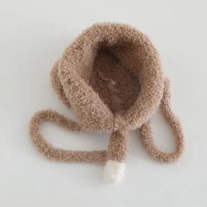 Detail of warm plush earflap hat for girls featuring soft knit fabric and tie-up chin straps