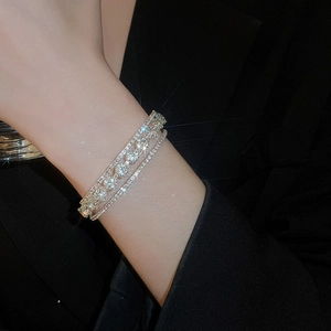Detail of multi-layer silver flower bracelet with sparkling rhinestones on model wrist