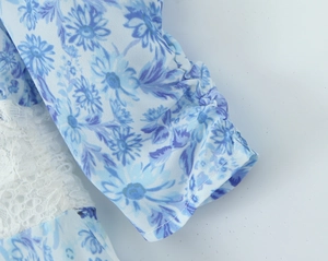 Close-up of blue floral print fabric with delicate white lace patchwork and pleated cuffs