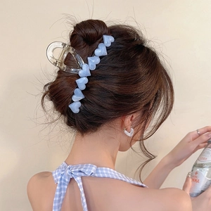 Blue heart-shaped hair claw clip and earring set shown on a model for a sweet summer look