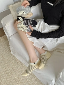 Close-up of low cut striped cotton socks with heart embroidery in a cozy home setting