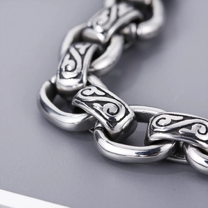Macro shot of vintage silver metal chain link with intricate totem patterns and textures