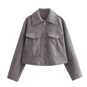 Detail of taupe tweed jacket featuring a lapel collar and a metal zipper closure