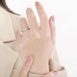 Detail of octagonal silver ring with micro-pave stones worn by a model in beige suit