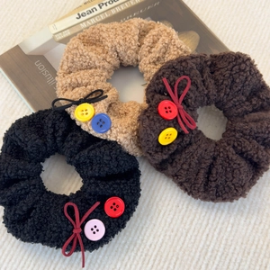 Trois chouchous en laine d'agneau pelucheuse avec nœud et boutons colorés d'automne