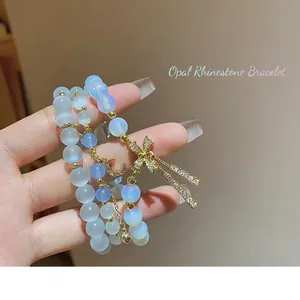 Three-layer blue cat eye bead bracelet with zircon bow and moon charms on hand