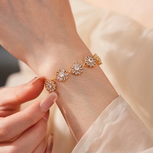 Close-up of gold plated floral bracelet with zircon stones on a model's wrist