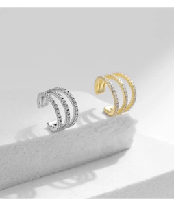 Close-up of triple-layered silver and gold ear cuffs with cubic zirconia inlay